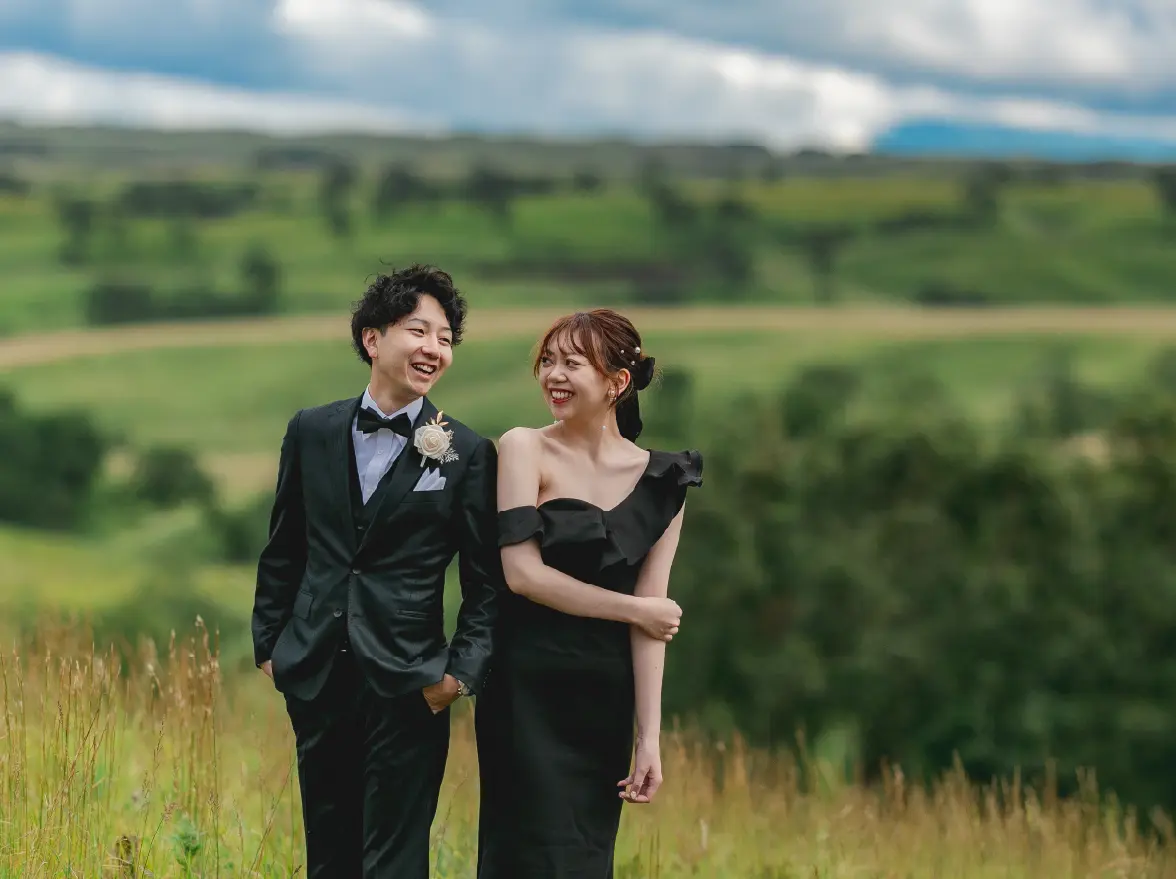 黒いドレスとタキシードに身を包む新郎新婦の写真